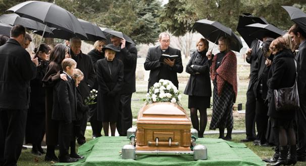 the-funeral-director-with-the-priest-at-a-graveside-service